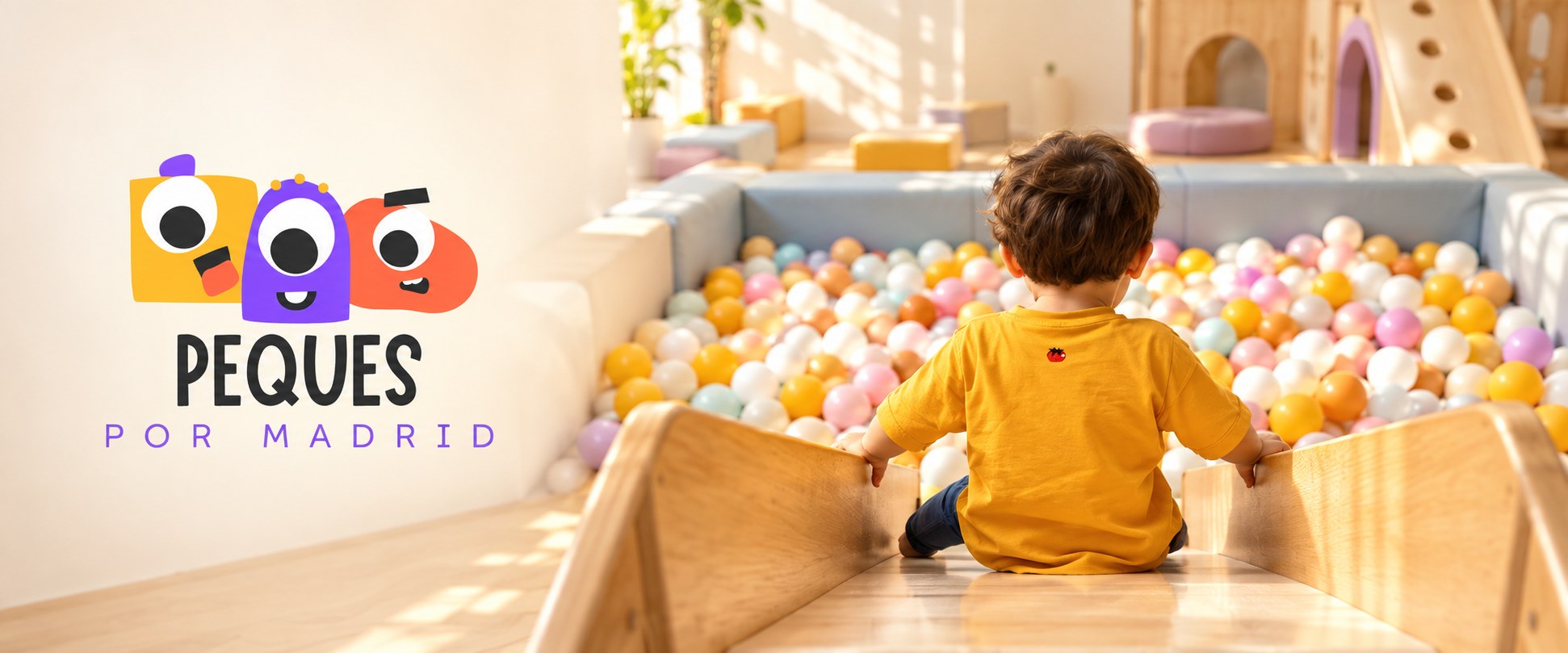Peques por Madrid: a child at the top of a slide beside a ball pit